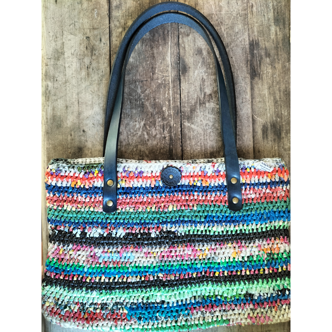 Multicoloured upcycled plastic handbag with navy blue leather handles