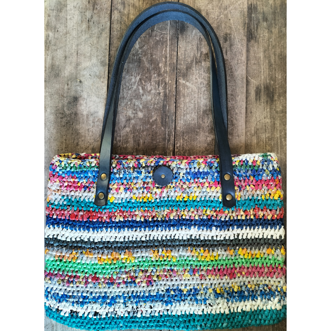Multicoloured upcycled plastic handbag with navy blue leather handles
